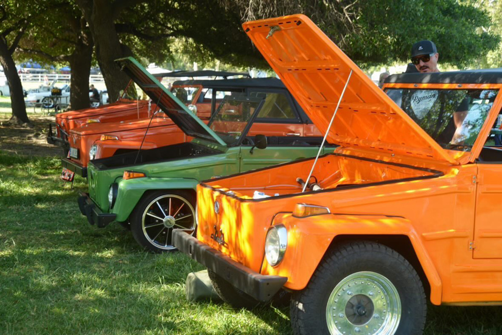 Brightly colored VW Thing lineup with hoods open at the El Prado VW Show & Shine
