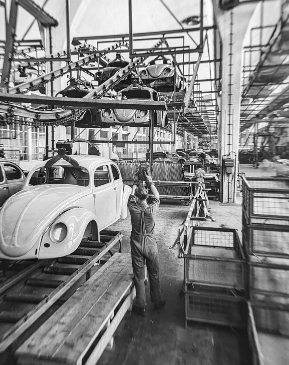An operator controls the arrival of painted bodies on an overhead chain conveyor into the hall for trimming and fitting out