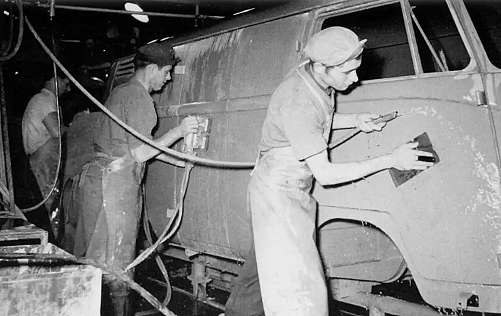 Workers wet-sand the primer on a Transporter panel van around the mid-1950s, so quite possibly at Volkswagenwerk Wolfsburg.